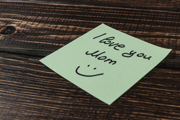 Simple note expressing love and gratitude to Mom on a wooden table