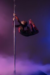Young girl performing a stunning pole dance routine with vibrant fabric