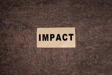 impact word text message on torn paper on dark background
