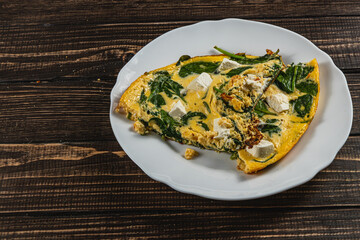 Fresh spinach and cheese frittata served on a rustic wooden table