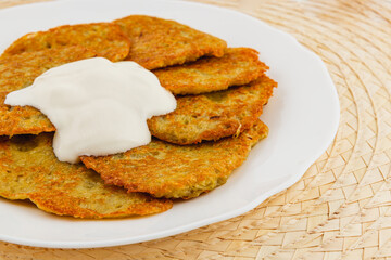 Delicious golden pancakes served with creamy topping on a white plate