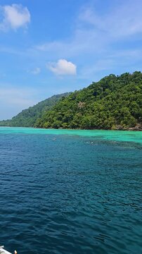 Immerse yourself in the breathtaking beauty of Surin Island in Thailand, where crystal-clear waters meet vibrant greenery, inviting adventure and relaxation under the sun.
