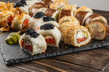 Sushi platter featuring various rolls topped with caviar and sesame seeds
