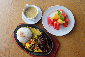 black hotplate rice vegetable fish chicken and meat  dinner with slice fruit