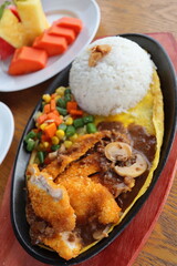 black hotplate rice vegetable fish chicken and meat  dinner with slice fruit
