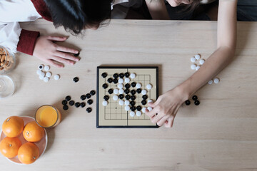 Close-up and top-view shots of GO, oriental checkers board game on wooden table are played by two...
