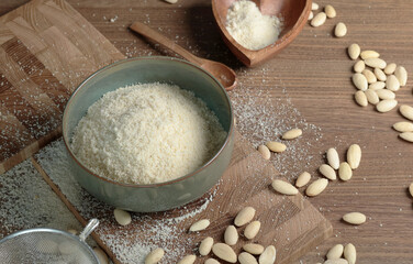 Almond flour in bowl. Nuts on table. Healthy food and products. Organic ingredients and vegan...