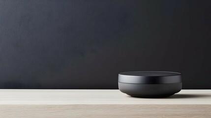 Black Cylindrical Container on Wooden Surface Against Dark Background