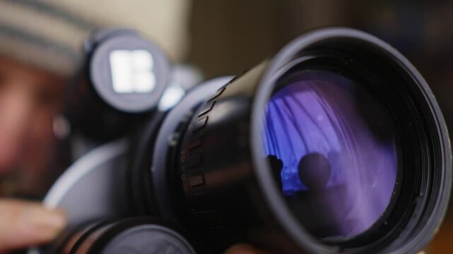 Filmmaker turns lens focus ring on vintage16mm film movie camera CLOSE UP