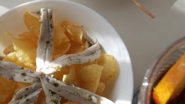 Tapas dish featuring Gildas, Boquerones, and crispy chips on a plate