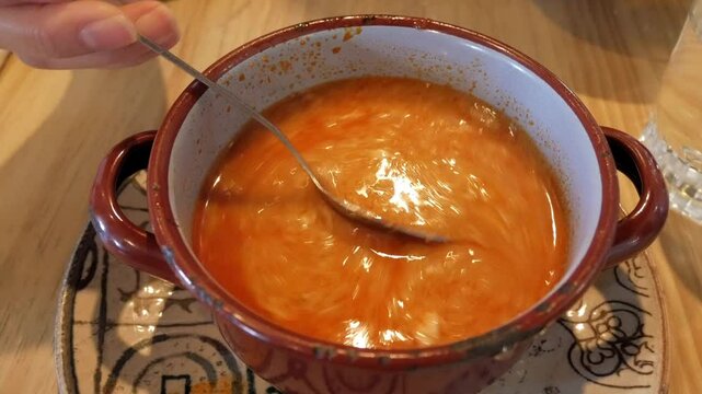Sopa Castellana being stirred in a rustic bowl, showing rich and flavorful soup