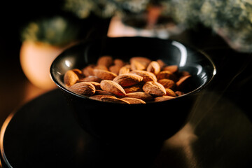 Bowl of raw almonds on a black background with attractive lighting for a stylish kitchen presentation