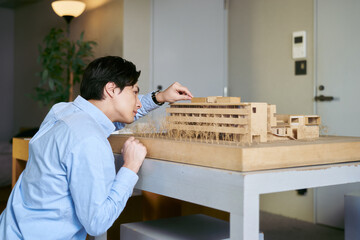 建物の模型を見て実際の建築物のシュミレーションを行う建築学科の学生