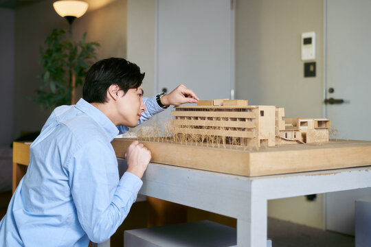 建物の模型を見て実際の建築物のシュミレーションを行う建築学科の学生