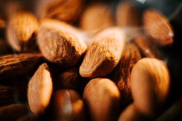 Almonds arranged neatly on a dark plate create a striking visual contrast against the black...