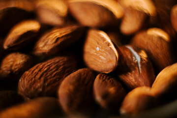 Almonds arranged on a plate against a black background showcasing their natural texture and color in close-up view