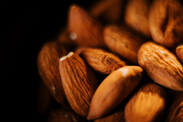 Delicious almonds arranged neatly on a plate against a dark background