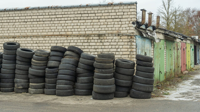 Panoramic view of storage of discarded old car tires outdoors, showcasing a pile of used tires ready for recycling. Highlighting environmental concerns and rubber waste management