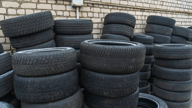 Storage of discarded old car tires outdoors, showcasing a pile of used tires ready for recycling. Highlighting environmental concerns and rubber waste management