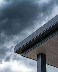 A modern building's roof edge under a dramatic, cloudy sky creates a striking contrast in architecture and nature.