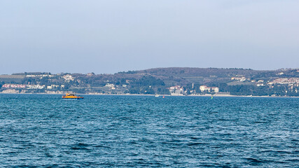 Calm sea with distant shoreline, marine vacation, coastal relaxation, peaceful blue water panorama
