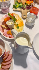 A lavish breakfast spread with sliced meats, cheeses, and cream jug, ideal for brunch gatherings, European cuisine, cozy continental morning meal feast