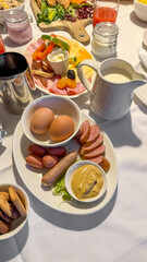 Hearty European breakfast spread with eggs, sausages, cold cuts, and fresh milk; ideal for morning feasts and cozy brunch gatherings