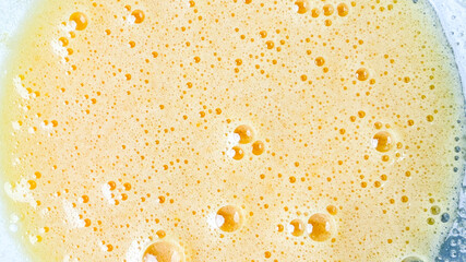Frothy, creamy mixture with bubbles, ideal for cooking and baking concepts, fresh homemade batter...