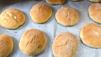 Freshly baked golden dinner rolls on parchment paper, homemade bread, comfort food, Thanksgiving preparation