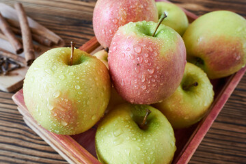 Apples in a wooden box on a rustic wooden background.