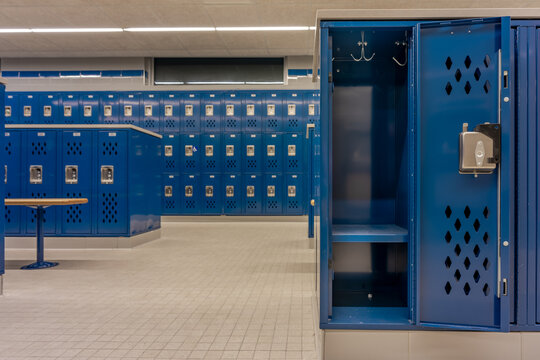 Empty team locker, locker room, changing room, with an open locker, with traditional blue metal lockers.	