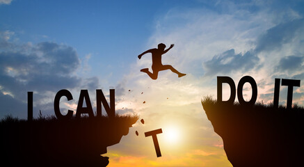 Silhouette man jumping over I can do it wording on cliffs with cloud sky and sunrise. Never give up, Good mindset, and Successful achievement Concept.
