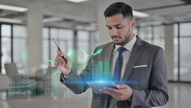 Businessman analyzing financial data on tablet: A focused and determined businessman examines financial data on his tablet, with green holographic charts and graphs overlaying his view.