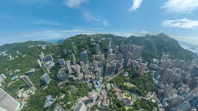 A 4K still video frame showing a Hong Kong aerial view, perfect for zooming in on the dense city nestled among lush green hills.