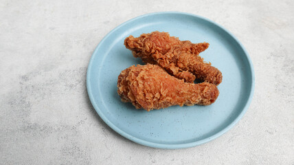 crispy kentucky fried chicken in a blue plate on black background, selective focus