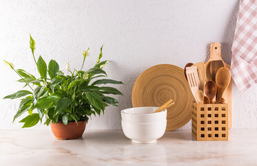 Beautiful kitchen background with wooden eco-friendly kitchen tools, utensils, potted plant. Front view. Stylish kitchen. Zero waste house concept