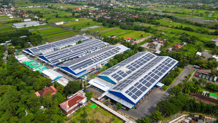 A vast factory rooftop is covered with solar panels, harnessing renewable energy for a greener and...
