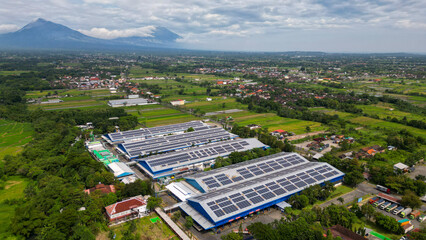 A vast factory rooftop is covered with solar panels, harnessing renewable energy for a greener and more sustainable future.