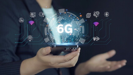 Businessman's hand holding a smartphone and future technology interface, hyper-connectivity, business innovation, 6G technology.