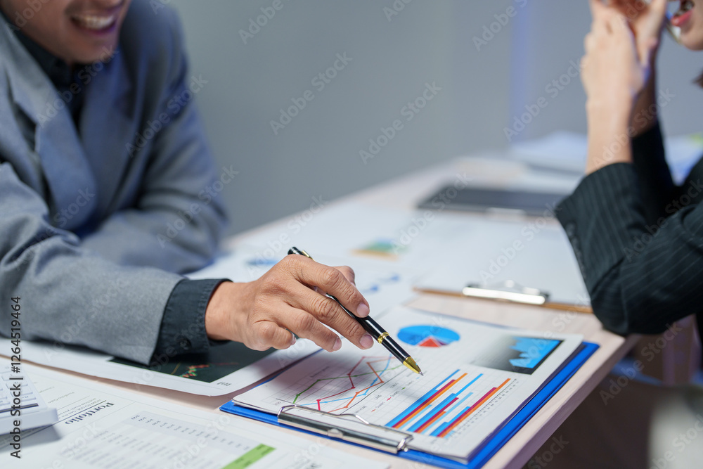 Poster financial advisor pointing at growth charts while explaining investment strategy to client during a 