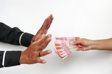 A portrait of businessman refusing money, Indonesian rupiah bills - anti-bribery and corruption...
