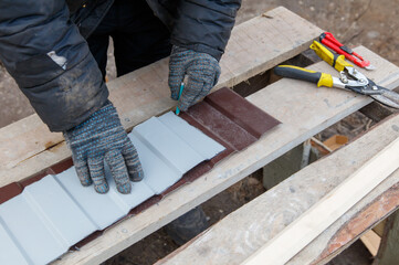 A man is cutting a piece of wood with a saw