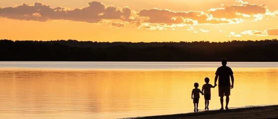 Fototapeta premium Father and children walking along a serene lakeside beach at sunset, enjoying quality family time and natures beauty in warm golden light.
