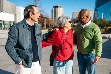 Three senior friends sharing a joyful moment in a city setting