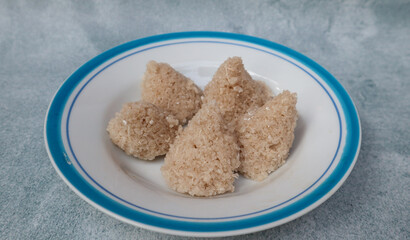 Tiwul, a traditional Indonesian food, is a staple food substitute for rice made from cassava. Usually eaten with a sprinkling of grated coconut. Served in white and blue plate