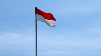 indonesian flag on cloudy blue sky background