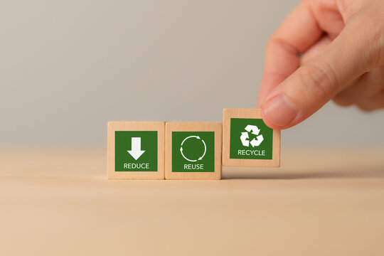 3Rs Concept. Reduce, Reuse, Recycle. Hand placing wooden block labeled "RECYCLE" representing sustainability: Reduce, Reuse and Recycle. Environmental responsibility and waste management.