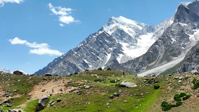 Static shot of rugged snow capped mountain landscape with rocky foreground in Skardu, Pakistan.