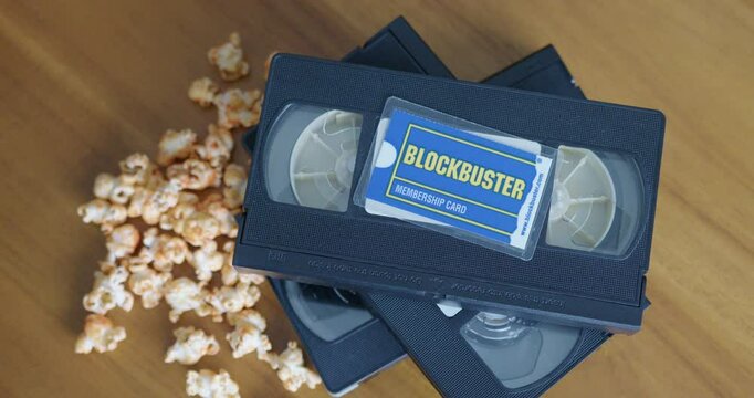 Wide Pan Right Shot of a Blockbuster Membership Card with VHS Tapes and Popcorn