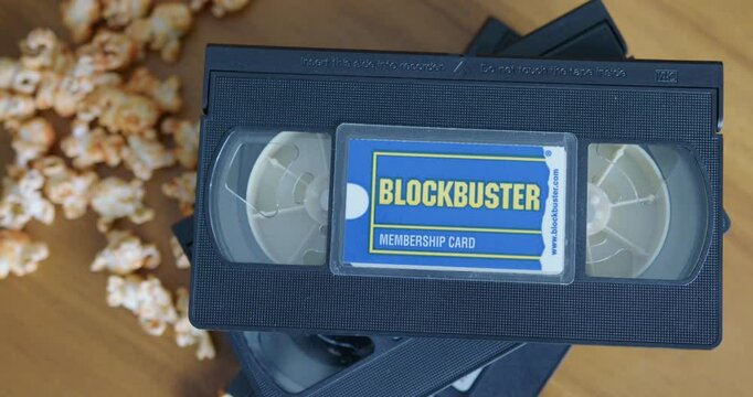 Close Up Pan Right Shot of a Blockbuster Membership Card with VHS Tapes and Popcorn